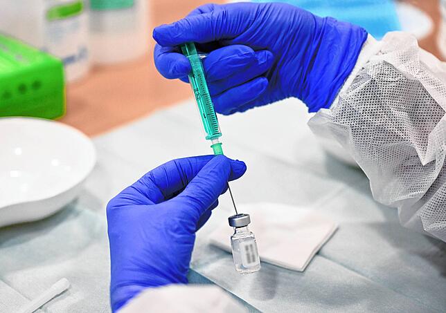 Eine Klinik-Mitarbeiterin bereitet in einer Impfstation eine Spritze für eine Impfung gegen das Coronavirus vor. Schwere Verläufe bei ...
