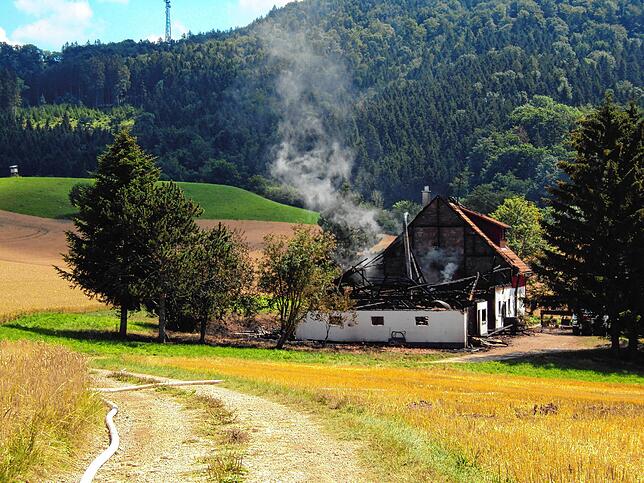 Der vom Brand zerstörte Aussiedlerhof bei Fützen: Auch nach der Brandnacht steigt noch Rauch auf.