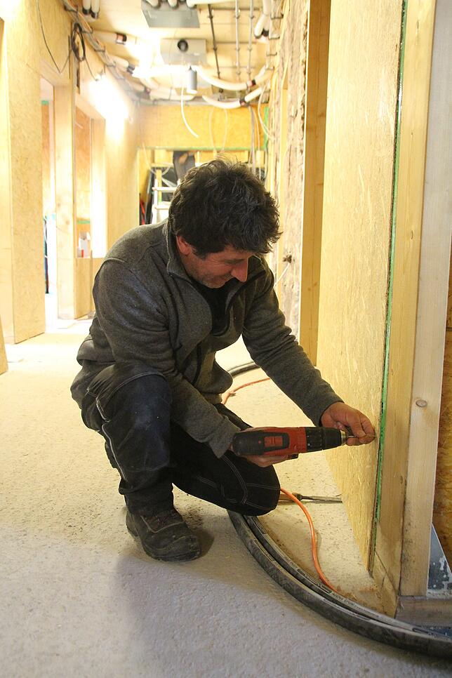 František Petruš bringt die Holzplatten für die Wände an.