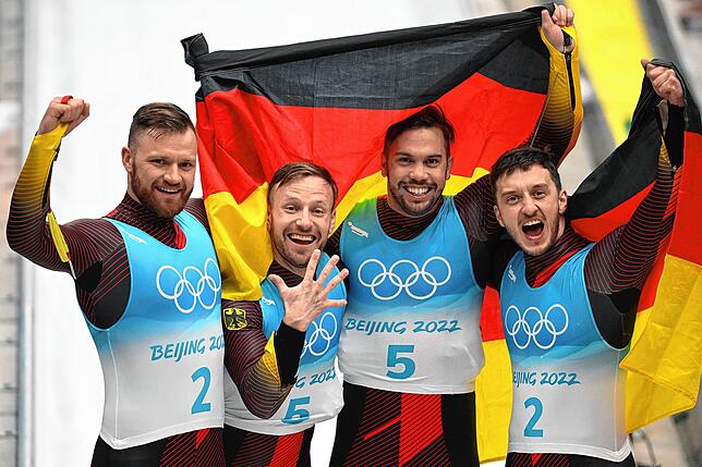 Tobias Wendl (Zweiter von rechts) und Tobias Arlt (links daneben) jubeln nach ihrem Olympia-Sieg im Rodel-Doppelsitzer, dem dritten in ...