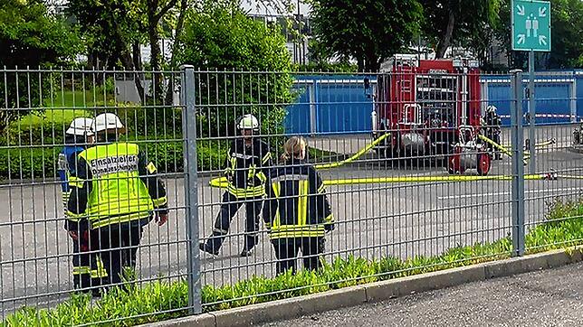 Die Einsatzkräfte der Feuerwehr mit Atemschutz (rechts im Bild) lassen die chemische Reaktion im Hof der Firma kontrolliert zu Ende ...