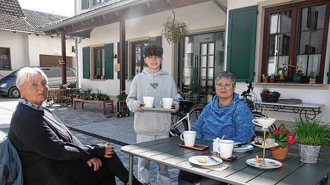 Ungewohnte Aufgabe: Schüler Jakob Renner serviert Martha Gassner und Ester Biller Cappuccino im Sonnenschein der Gartenwirtschaft der ...