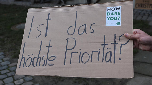 Mit einem Plakat spielen die Aktivisten von Fridays for Future auf die &bdquo;Aufgabe höchster Priorität&ldquo; an, als die der ...