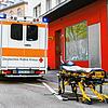 Eine leere Trage steht vor einem Rettungswagen.