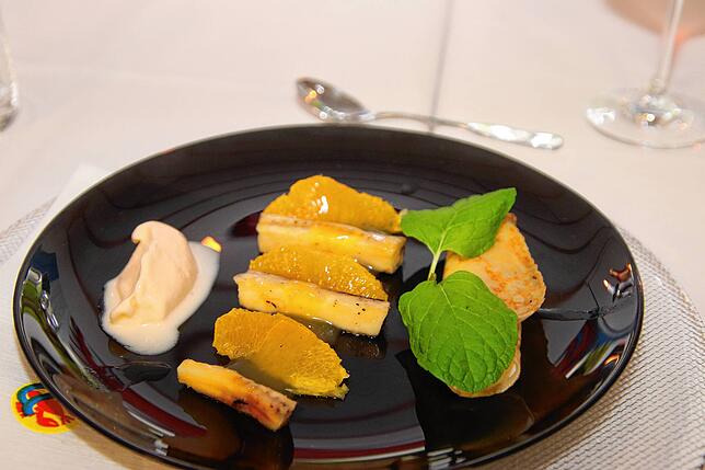 Erlesenes Dessert: Flambierte Banane mit filetierter Orange und Kokoseis. Dank aufwändiger Zubereitung ein Gaumenfeuerwerk.