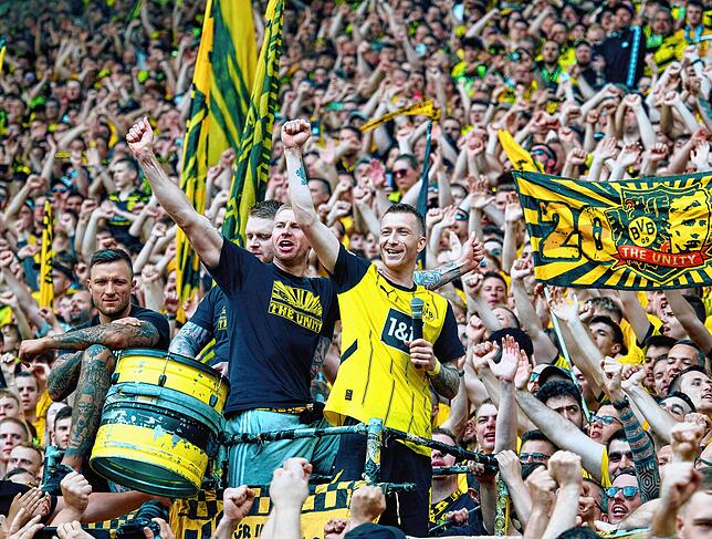 Dortmunds Marco Reus (r) feiert nach dem Spiel zwischen den Fans der Südtribüne.