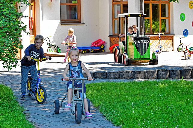 Im katholischen Kindergarten St. Verena flitzen Elias und Stella (vorne) durch den Garten.