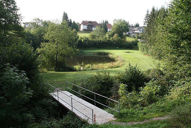 Der Blick vom Dorfbach aus in Richtung Hauptstraße heute. Die 18-Loch-Golfanlage erfreut sich großer Beliebtheit.