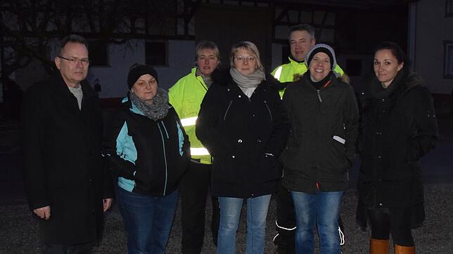 Ein Mitarbeiter des Landratsamts (links), der namentlich nicht genannt werden möchte, und mehrere Eltern kommen an der Haltestelle ins ...