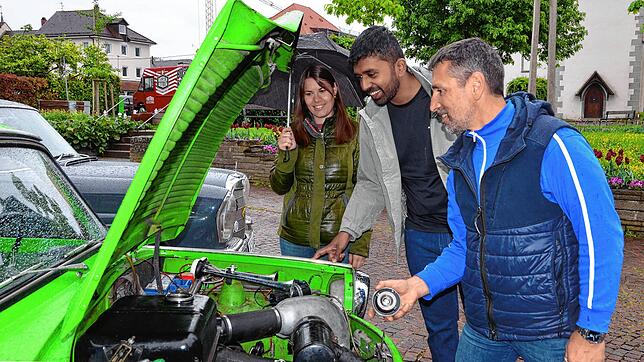 Einen Blick unter die Motorhaube erlaubt der Trabbi-Besitzer Lutz Müller zwei Besuchern der Oldtimer-Show auf dem Marktplatz. Das Auto ...