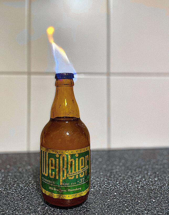 Das Feuer dient dazu, die Flaschenöffnung zu sterilisieren, ehe die geöffnet wird.