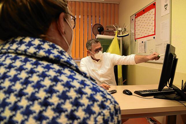 Alexandros Kantas im Gespräch mit einer Patientin im Besprechungszimmer (nachgestelltes Bild).
