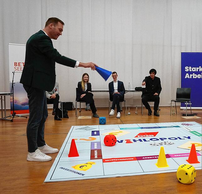 Der CDU-Kandidat Felix Schreiner schaut, in welches Themenfeld er, entsprechend der gerade gewürfelten Zahl, seinen Spielkegel setzen muss.