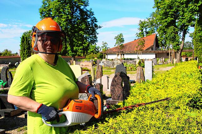 Teresa Beck arbeitet mit der Heckenschere auf dem Friedhof.