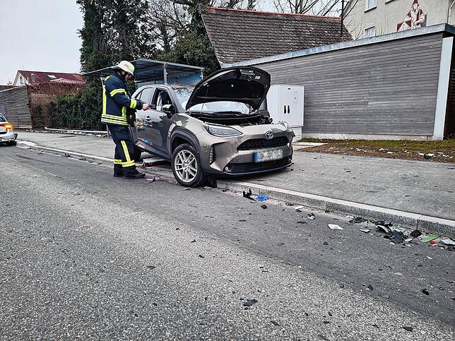 Ein Feuerwehrmann arbeitet an einem der Unfallfahrzeuge.