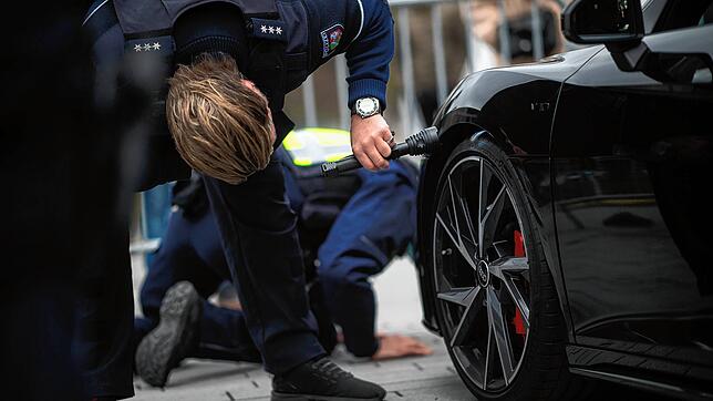 Ein Polizist überprüft auf dem Corneliusplatz das Fahrzeugprofil eines Sportwagens. Die Polizei führte am sogenannten ·Carfreitag· ...