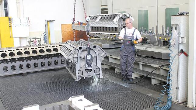 Ein Mitarbeiter von Rolls-Royce Power Systems (RRPS) reinigt im Werk 2 in Friedrichshafen einen Dieselmotor der Baureihe 4000. Im ...