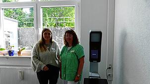 Milena Maier (links) und Daniela Rauch vom Bürgerbüro präsentieren den neuen Automaten, mit dem Passbilder im Blumberger Rathaus in ...