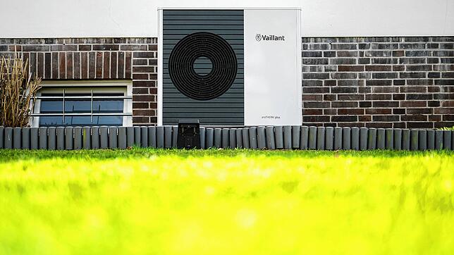 Eine Wärmepumpe steht vor einem Einfamilienhaus.