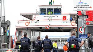 Vier Mitarbeiter des Zolls erwarten die Fähre am Anleger in Friedrichshafen. Alle Fahrgäste werden kontrolliert.