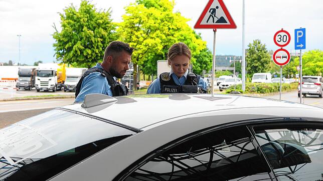 Bundespolizisten kontrollieren an der Schweizer Grenze ein Auto.