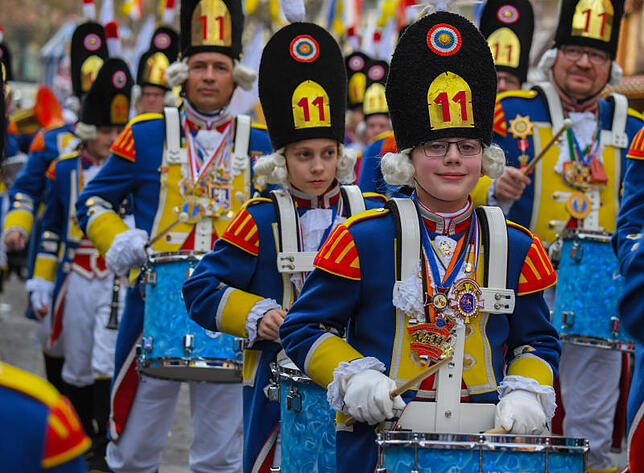 Gardisten marschieren beim Mainzer Rosenmontagsumzug in ihrer traditionellen Uniform, die an eine Militäruniform aus dem 18. Jahrhundert ...