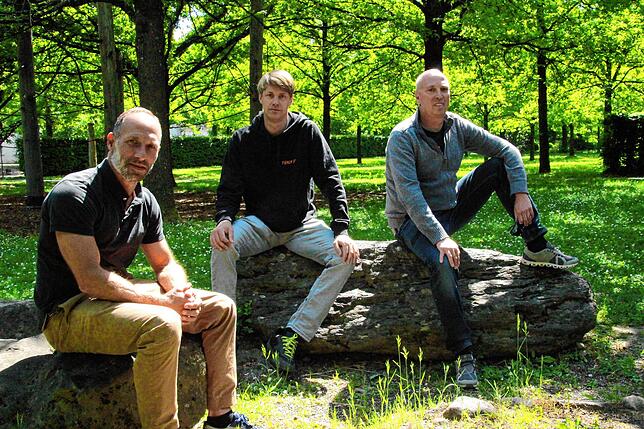 Tommy Spörrer, Frank Schuwerkh und Björn Brüggemann von der Vulcano GbR sitzen im Eichenhain. Im Hintergrund hätte das Singener Weinfest ...
