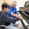 Manuel Wagner zeigt dem achtjährigen Louis die Griffe auf dem Klavier.