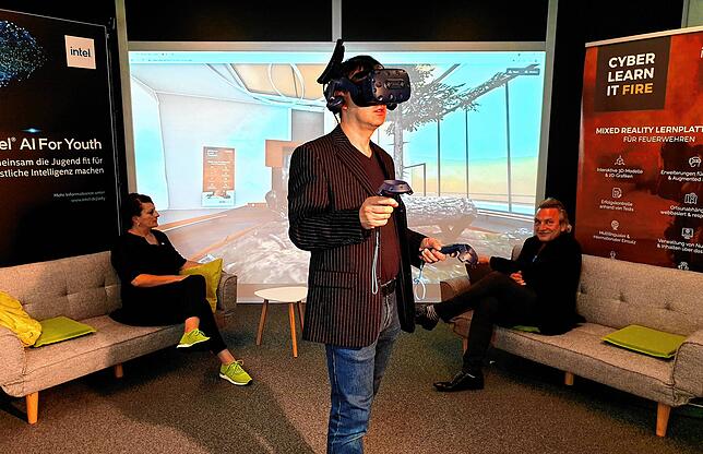 Christop Gawel, Trainer und Eventmanager von VDC, wandelt mit einer VR-Brille durch die virtuell erschaffene Akademie im Hintergrund. ...