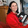 Susanne Strauß mit einem Fotoalbum, in dem sie Zeitungsartikel und Bilder ihrer Söhne gesammelt hat.