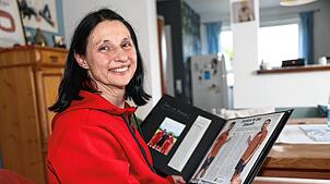 Susanne Strauß mit einem Fotoalbum, in dem sie Zeitungsartikel und Bilder ihrer Söhne gesammelt hat.