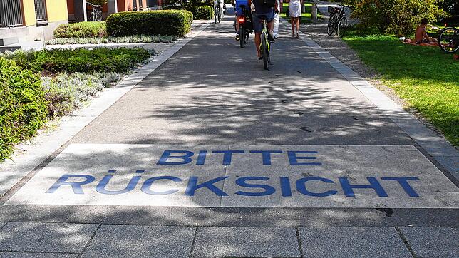 Die Aufforderung zur Rücksichtnahme in großen blauen Buchstaben beim Herosépark. Radfahrer fahren meist achtlos darüber hinweg, hier ...