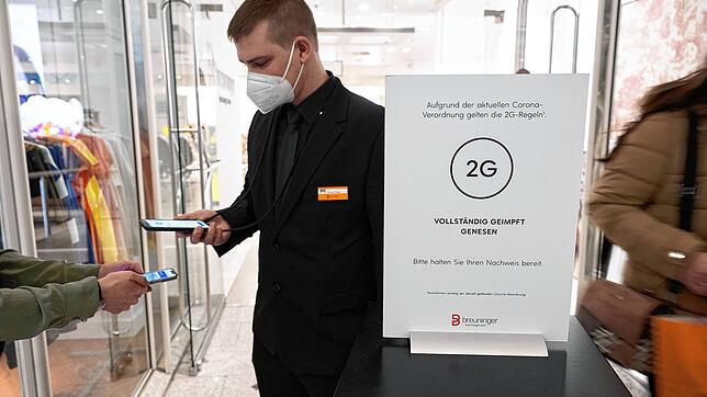 Ein Mitarbeiter eines Stuttgarter Kaufhauses kontrolliert am Eingang den Impfnachweis einer Kundin. Inzwischen gilt wieder 3G im ...