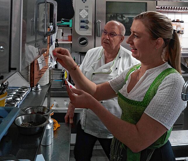 Juniorchefin Julia Partikel heftet Bestellungsbons an das Küchenklemmbrett, damit ihr Vater und das Küchenteam wissen, was es zu Kochen ...