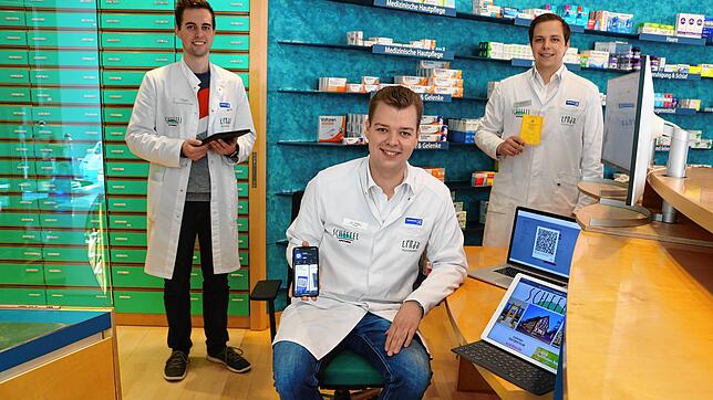 Einige der Apotheker, die die digitalen Impfpässe und QR-Papierausdrucke ausgeben: sitzend Jan Siefert, dahinter links Pirmin Hauser und ...