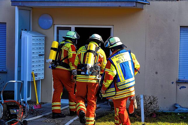 Feuerwehrleute dringen mit Atemschutz-Ausrüstung in das Brandobjekt vor.