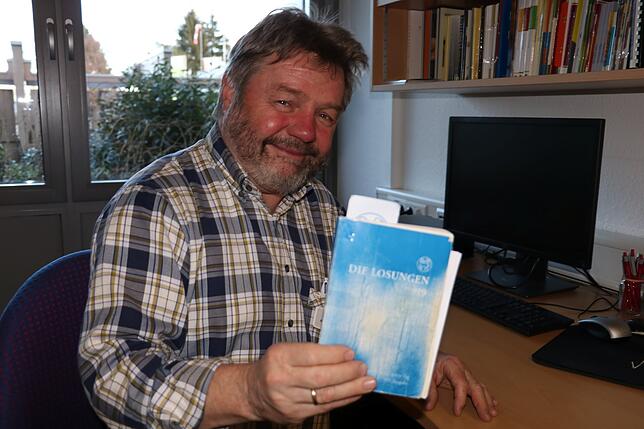 Ein abgegriffenes, aber wichtiges Arbeitsmittel: Jörg Makarinus-Heuß zeigt sein Losungsbuch.