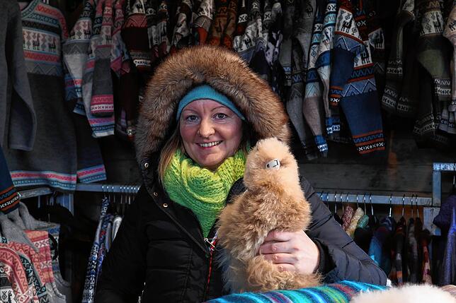 Katja Lacher mit einem Alpaka – neben Schals, Decken und Pullovern aus Alpakawolle gibt es auch die Tierfiguren zu kaufen.