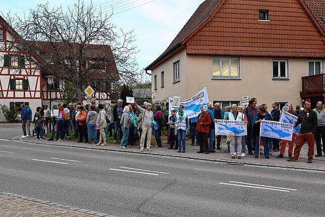 Rund 100 Personen haben sich entlang der Straße versammelt, darunter auch die Omas gegen Rechts.