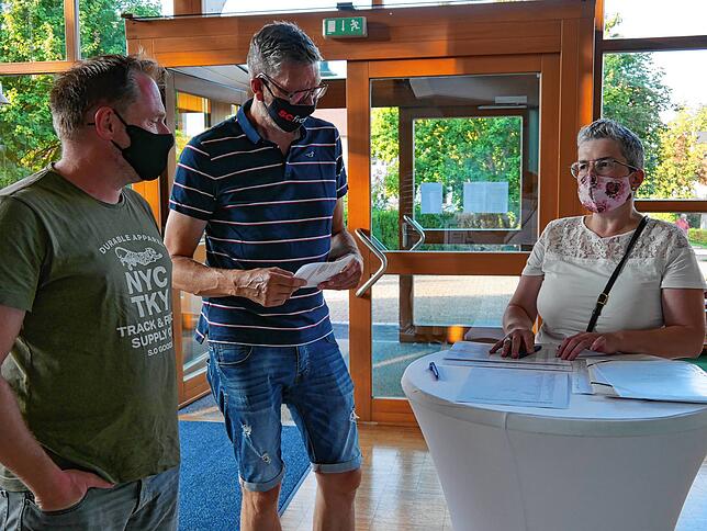 SÜDKURIER-Mitarbeiterin Doris Eichkorn (rechts) begrüßt Daniel Hepfer und Ingo Kempter am Einlass.