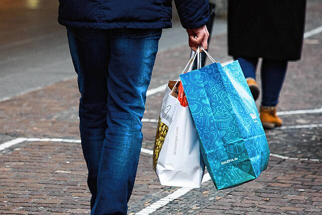 In Freiburg trägt ein Mann Einkaufstüten durch die Innenstadt. In Normalzeiten kaufen viele Schweizer auf deutscher Seite ein.