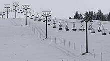 Ein Lift steht auf dem Feldberg im Schwarzwald über einem schneebedeckten Hang. Das Ski-Vergnügen kann starten.
