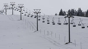 Ein Lift steht auf dem Feldberg im Schwarzwald über einem schneebedeckten Hang. Das Ski-Vergnügen kann starten.
