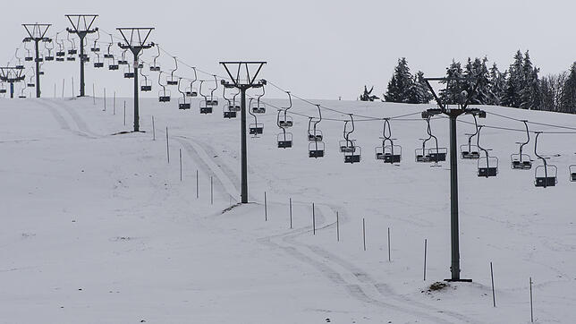 Ein Lift steht auf dem Feldberg im Schwarzwald über einem schneebedeckten Hang. Das Ski-Vergnügen kann starten.