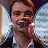 Stefan Hain, Leiter der Halbleiterentwicklung bei ZF, hält ein Leistungsmodul eines Energiewandlers vor einen Wafer.