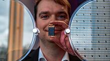 Stefan Hain, Leiter der Halbleiterentwicklung bei ZF, hält ein Leistungsmodul eines Energiewandlers vor einen Wafer.