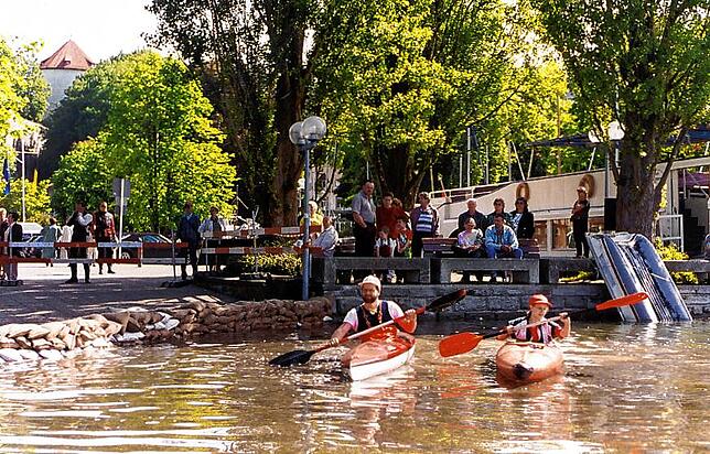 Zwei Kanufahrer kommen in Überlingen den Fußgängern nah. Das Hochwasser machte es möglich.