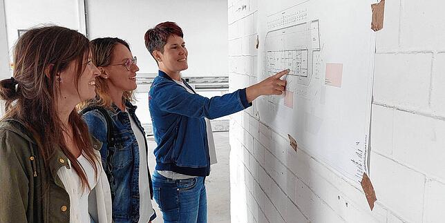 Die drei Leiterinnen Julia Schollenberger, Sabine Kutscher und Mareike Pranschke schauen sich Pläne ihrer künftigen Kita an.