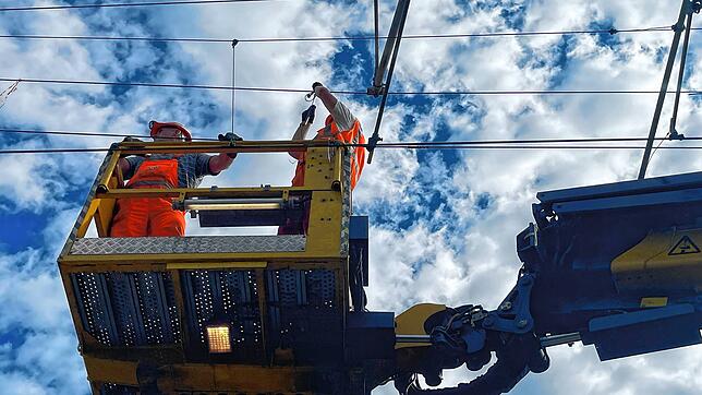 Komplizierte Reparatur: Arbeiter setzen nach dem schweren Gewittersturm die beschädigte Oberleitung der Bahnstecke Radolfzell-Konstanz ...