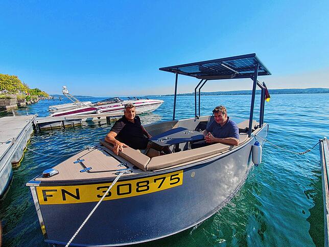 Vor der Uferpromenade von Überlingen festgemacht: Markus Betz (links) und Eric Hueber in ihrem Solarboot.